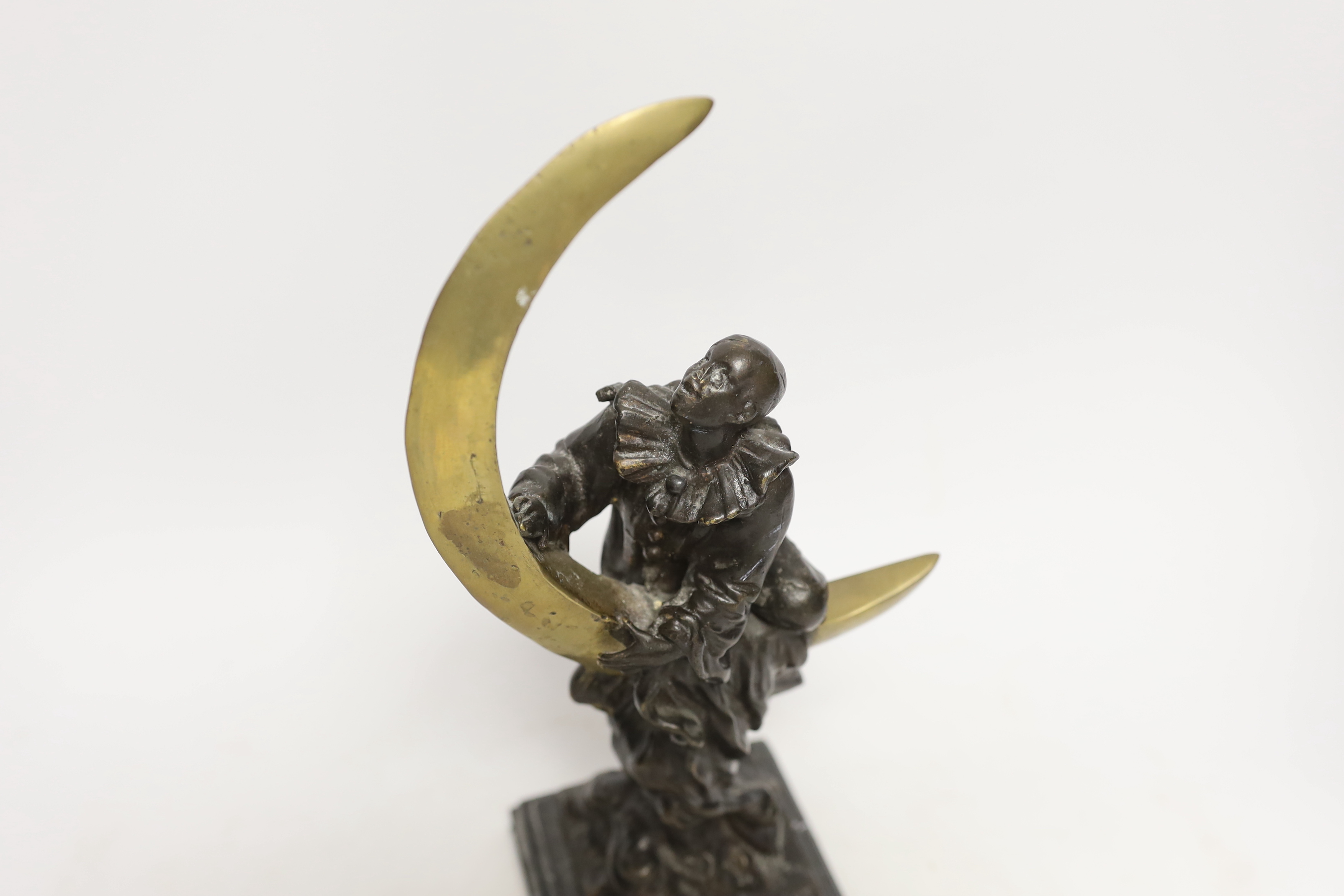 After Claire Colinet (1885-1972), a bronze study of a Pierrot and crescent moon, raised on stepped marble base, 33cm high